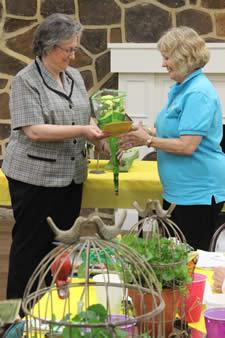 (Left) Incoming president, Robbie Kerr, presents outgoing president, Colleen Dogget, with a bouquet of roses